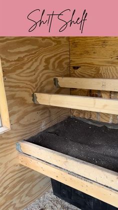 the inside of a building with wood framing and black plastic bags in it's bottom shelf