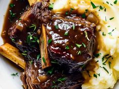 a white plate topped with mashed potatoes and beef