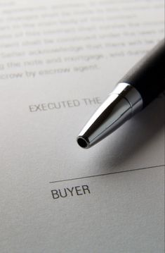 a pen sitting on top of a paper with the word buyer written in it's center