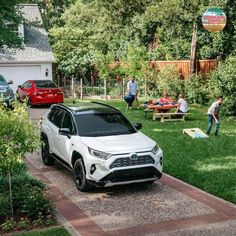 a white toyota rav parked on the side of a road next to a picnic table