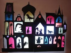 the silhouettes of houses are lit up in different colors and shapes, including buildings