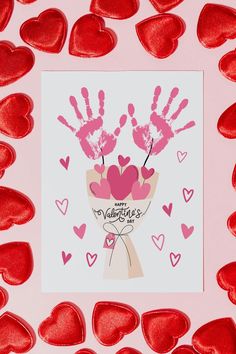 valentine's day card with handprints and hearts on pink paper surrounded by red foil