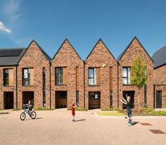 two children are playing in front of some brick buildings with bicycles parked on the sidewalk