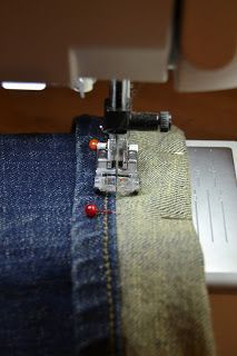 the sewing machine is working on the jeans