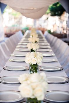 the long table is set with white flowers