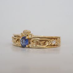 a gold ring with a blue stone in the center and two diamonds on each side