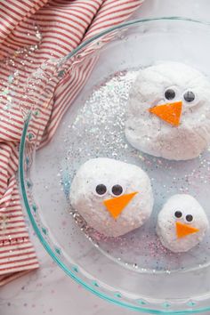 three snowmen made out of rice krispy kreme on top of a glass bowl