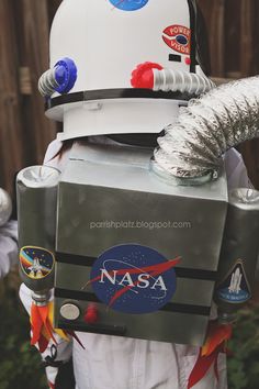 a man dressed up in an astronaut suit with nasa patches on his chest and helmet