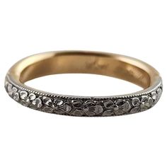 an antique wedding ring with filigrees on the sides and floral design in yellow gold