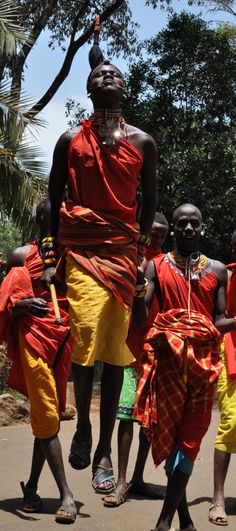 some people are walking down the street with their heads wrapped in red and yellow cloths