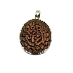 These beautiful pendants are original designs from Tulasi Maharani Jewellery.  They are carved in Tulasi wood and casted in Sterling silver , all by hand !  GURU CHARAN ( feet ): blessings from the Gurus or Guides  SHREE RADHE : the divine feminine's name  TULASI PLANT : the holiest of plants , mother of devotion.  You can get yours alone , on a black thread with silver clasps , on a silver chain or on a Tulasi and silver chain Traditional Brown Carved Jewelry, Brown Carved Spiritual Jewelry, Spiritual Brown Carved Jewelry, Brown Engraved Round Pendant Jewelry, Traditional Carved Pendant Jewelry, Traditional Carved Medallion Necklace, Traditional Carved Medallion Necklaces, Artisan Carved Jewelry For Meditation, Carved Necklaces For Festivals And Gifts