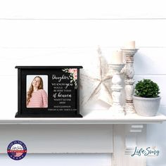 a memorial photo frame with a starfish on the shelf next to candles and a potted plant