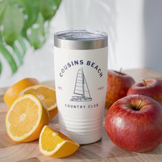 oranges, apples and an apple sit on a cutting board with a logo for the coursins beach country club