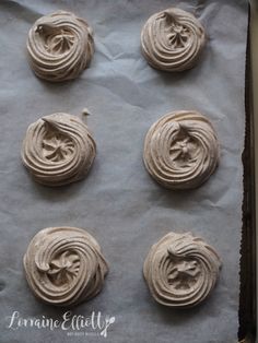 six cookies with icing sitting on top of a baking sheet