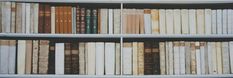 a book shelf filled with lots of books on top of white shelves next to each other