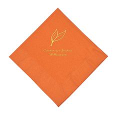 an orange napkin with a leaf on it