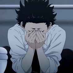 an anime character sitting on the floor with his hands covering his face while looking at something