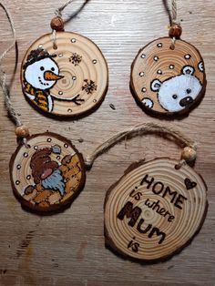 four wooden ornaments with different designs on them hanging from string and wood planks that say home is where mom is