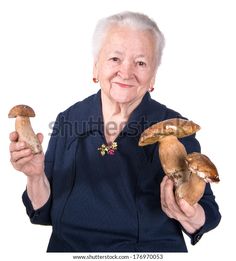 an elderly woman holding two mushrooms in her hands and smiling at the camera, on a white background