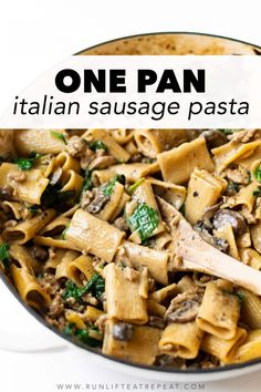 one pan italian sausage pasta with spinach and mushrooms in a skillet on a white surface