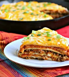 a slice of lasagna on a white plate with a red and yellow towel