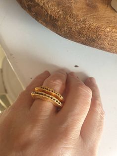 This is a very elegant ring set with 9-11 black saphire. It is a wavy asymmetrical ring. Its made of goldFilled that will not tarnish. - Goldfilled - Set with 9-11 blue sapphire -Free shipping -Comes in a gift box If you would like to see other rings I have made, please follow this link: https://www.etsy.com/il-en/shop/TamyZurTachshit?ref=seller-platform-mcnav&section_id=17271018 If you would like to go back to my store follow this link: https://www.etsy.com/il-en/shop/TamyZurTachshit?ref=se Elegant Yellow Gold Rings With Black Spinel, Elegant Yellow Gold Ring With Black Spinel, Fine Jewelry Black Spinel Sapphire Ring For Anniversary, Fine Jewelry Sapphire Ring With Black Spinel For Anniversary, Elegant Gold Ring With Black Spinel, Elegant Gold Rings With Black Spinel, Formal Yellow Gold Rings With Black Spinel, Black Spinel Sapphire Ring For Anniversary, Elegant Yellow Gold Rings With Black Diamonds