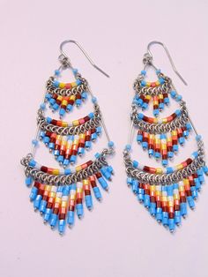 These gorgeous earrings were hand beaded in Peru. They measure 3 inches in length, 1 inch in width, with surgical steel ear wires. Artisan Beaded Earrings With Metal Ear Wire, Silver Southwestern Beaded Earrings With Ear Wire, Southwestern Silver Beaded Earrings With Ear Wire, Dangle Beaded Earrings For Festivals With Ear Wire, Dangle Beaded Earrings With Ear Wire For Festivals, Dangle Beaded Earrings For Festivals, Festival Dangle Beaded Earrings With Ear Wire, Festival Beaded Dangle Chandelier Earrings, Festival Chandelier Earrings With Round Beads