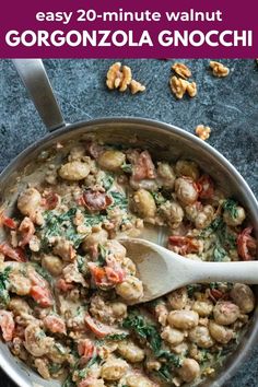 a pan filled with chicken and spinach covered in sauce next to walnuts on the side