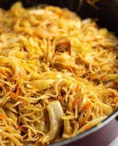 a pan filled with noodles and vegetables on top of a stove