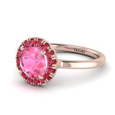 a pink stone ring with the word segit engraved on it's center and surrounded by small red stones