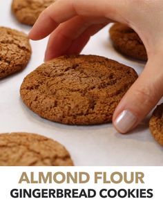 a close up of a person touching a cookie with the words almond flour gingerbread cookies