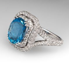 This enchanting ring is centered with one (1) richly hued oval cut Santa Maria aquamarine set into a four-prong setting. The double halo and shoulders of the ring are decorated with a total of two-hundred six (206) pavé/ prong set round brilliant cut diamonds. The ring measures 16.2mm at the top, rises 10.2mm above the finger, tapering to 2.0mm wide and 1.3mm thick at the base of the shank. The ring is currently a size 6.75 and sizing will be limitted due to the design. Please feel free to call with sizing inquires. Gia Certified Oval Blue Topaz Ring, Luxury Topaz Ring With Halo Design For Formal Occasions, Formal Oval Topaz Ring With Halo Setting, Formal Oval Topaz Ring With Halo Design, Luxury Formal Topaz Halo Ring, Dazzling Oval Topaz Ring With Halo Setting, Elegant Oval Topaz Ring With Halo, Elegant Oval Topaz Halo Ring, Aquamarine Ring