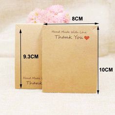 two brown boxes with thank written on them and a pink carnation in the middle