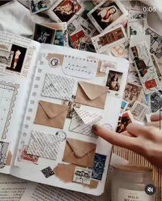 an open book with lots of stamps on it and someone's hand pointing at the pages