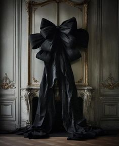 a black bow is hanging on the wall