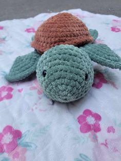 a crocheted turtle laying on top of a blanket