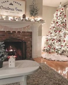 a living room with a christmas tree and fireplace