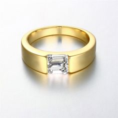 a gold ring with an emerald cut diamond