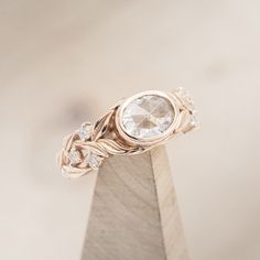 a diamond ring sitting on top of a wooden stand