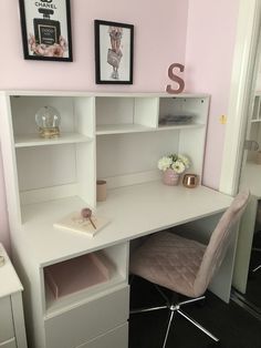 a white desk and chair in a room with pink walls, black flooring and pictures on the wall