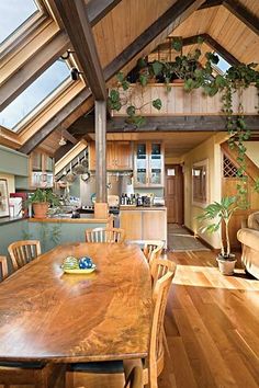 a wooden table sitting under a skylight in a living room next to a couch