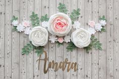 some flowers and the word anara spelled out in gold lettering on a wooden background