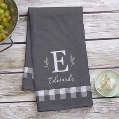 the personalized dish towel is next to a bowl of grapes and an empty plate