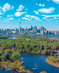 an aerial view of the city skyline, with boats in the water and trees surrounding it