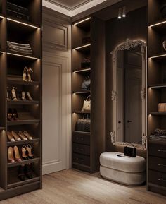 a walk in closet with lots of shoes on the shelves and lights hanging from the ceiling