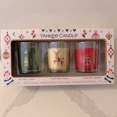 three candles are in a box with christmas decorations on the top and bottom one is decorated