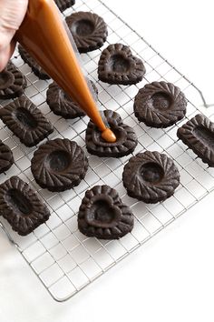 a person is spreading icing on some cookies