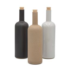 three different colored bottles with cork tops