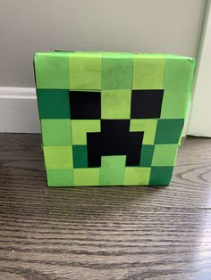 a green and black box sitting on top of a wooden floor