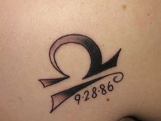 the back of a woman's stomach with a tattoo on it that reads q